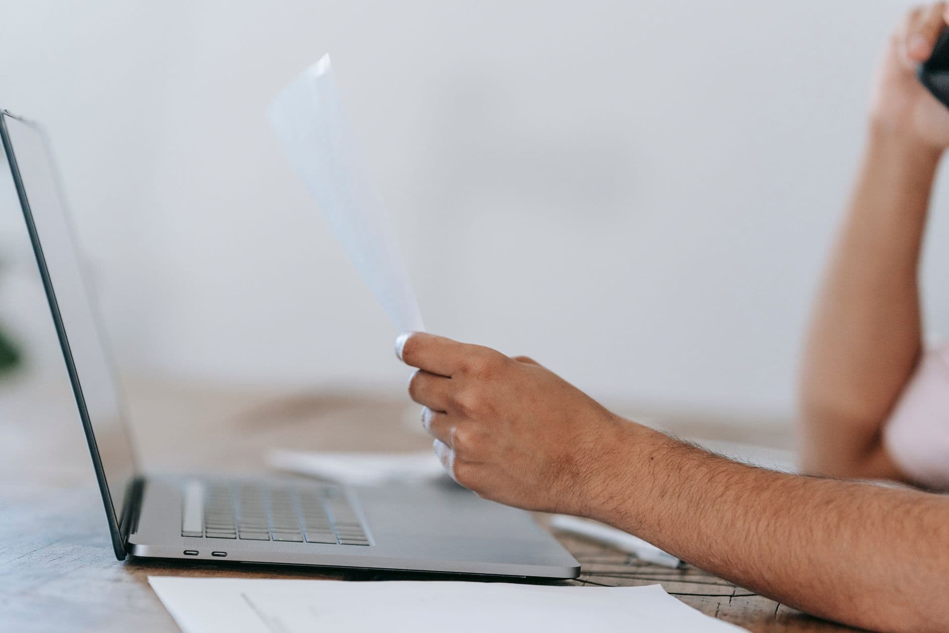 Prestadora de serviços conferindo dados fiscais em um computador no escritório.