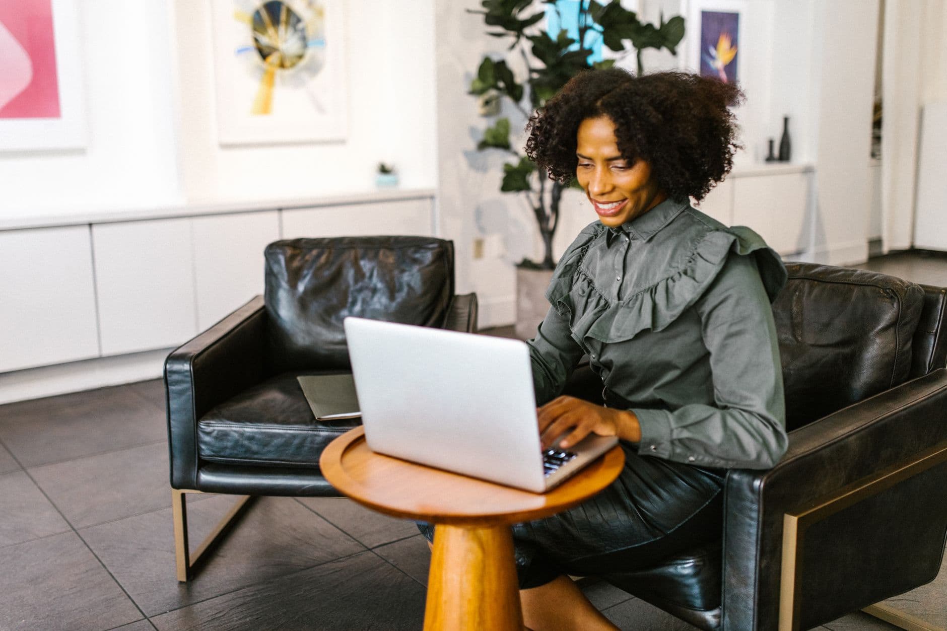 Confident woman working on a laptop in a stylish office environment.