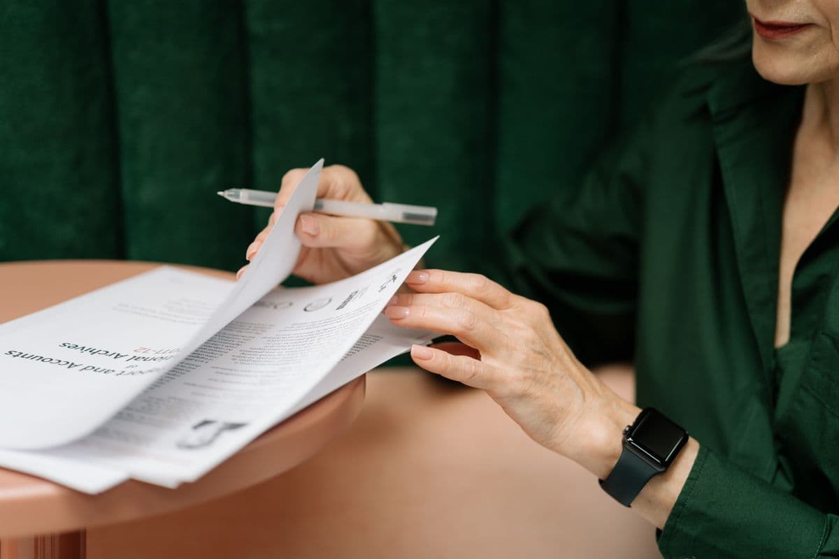 Prestadora de serviços analisando documentos de abertura de empresa em uma mesa de trabalho