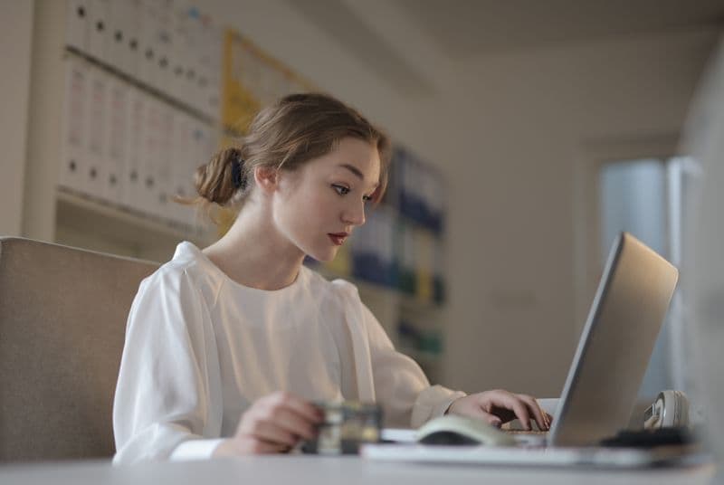 Como cancelar uma NFS-e quando o prazo passou Focused young woman working remotely on a laptop in a modern office.