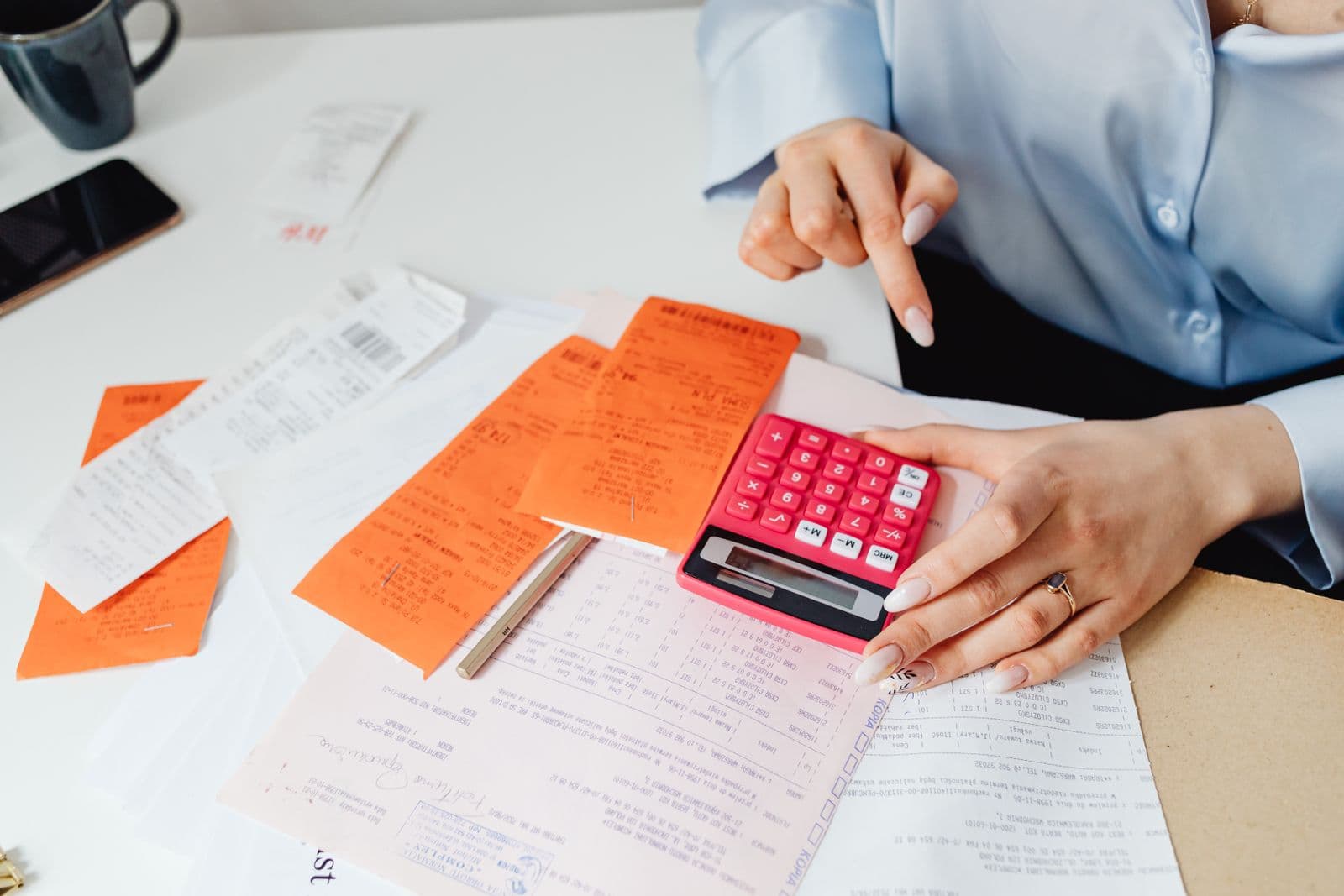 Profissional calculando valores com calculadora e recibos na mesa