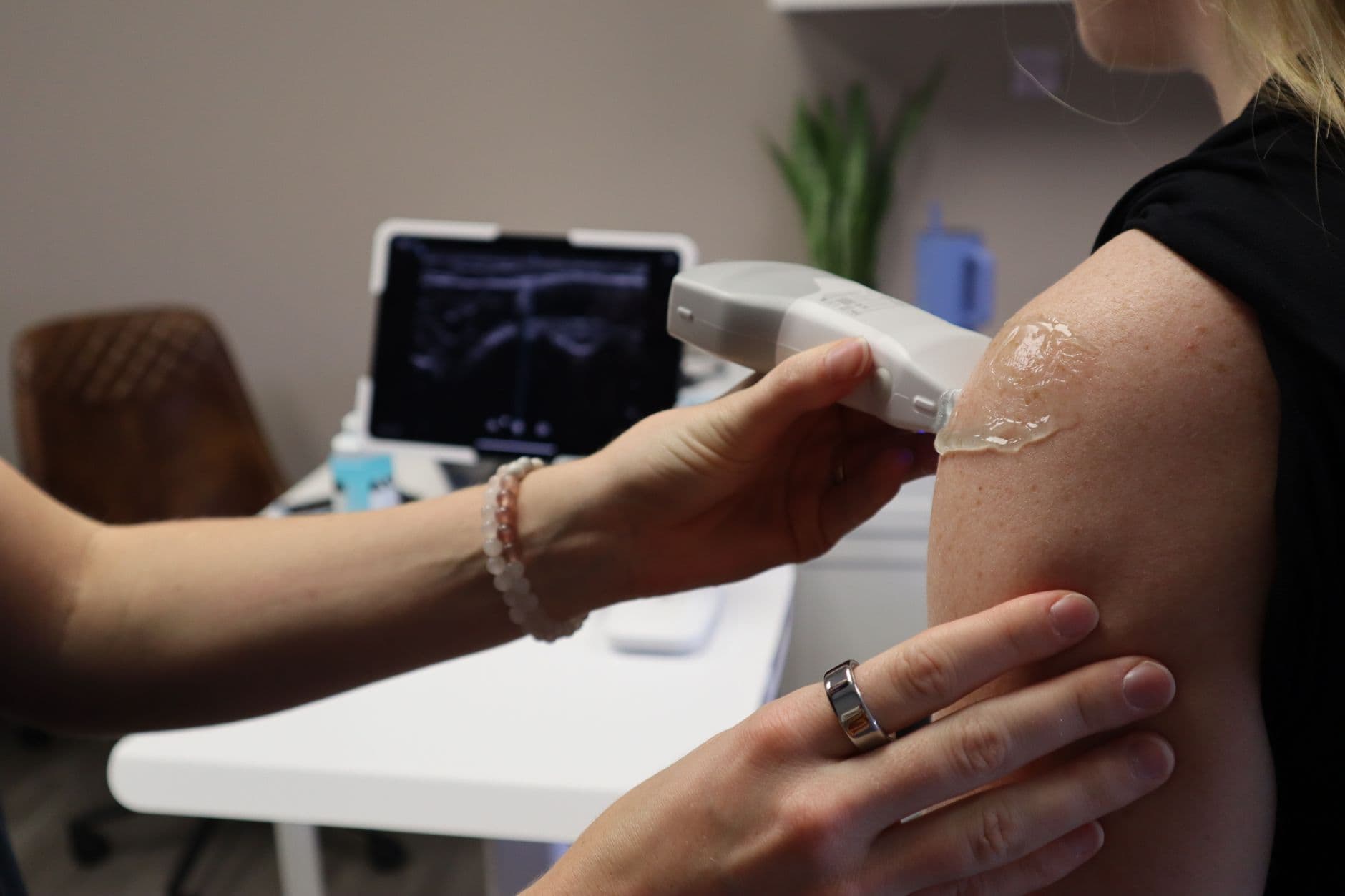 Como baixar o XML e o PDF da NF-e Healthcare professional performs ultrasound on patient's shoulder for medical assessment in clinic.
