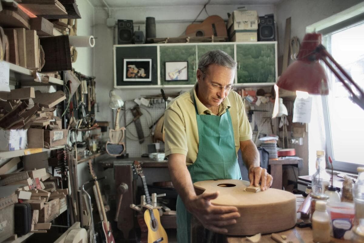 Quando a atividade não é permitida no MEI Artesão de avental trabalhando em peça de madeira na oficina