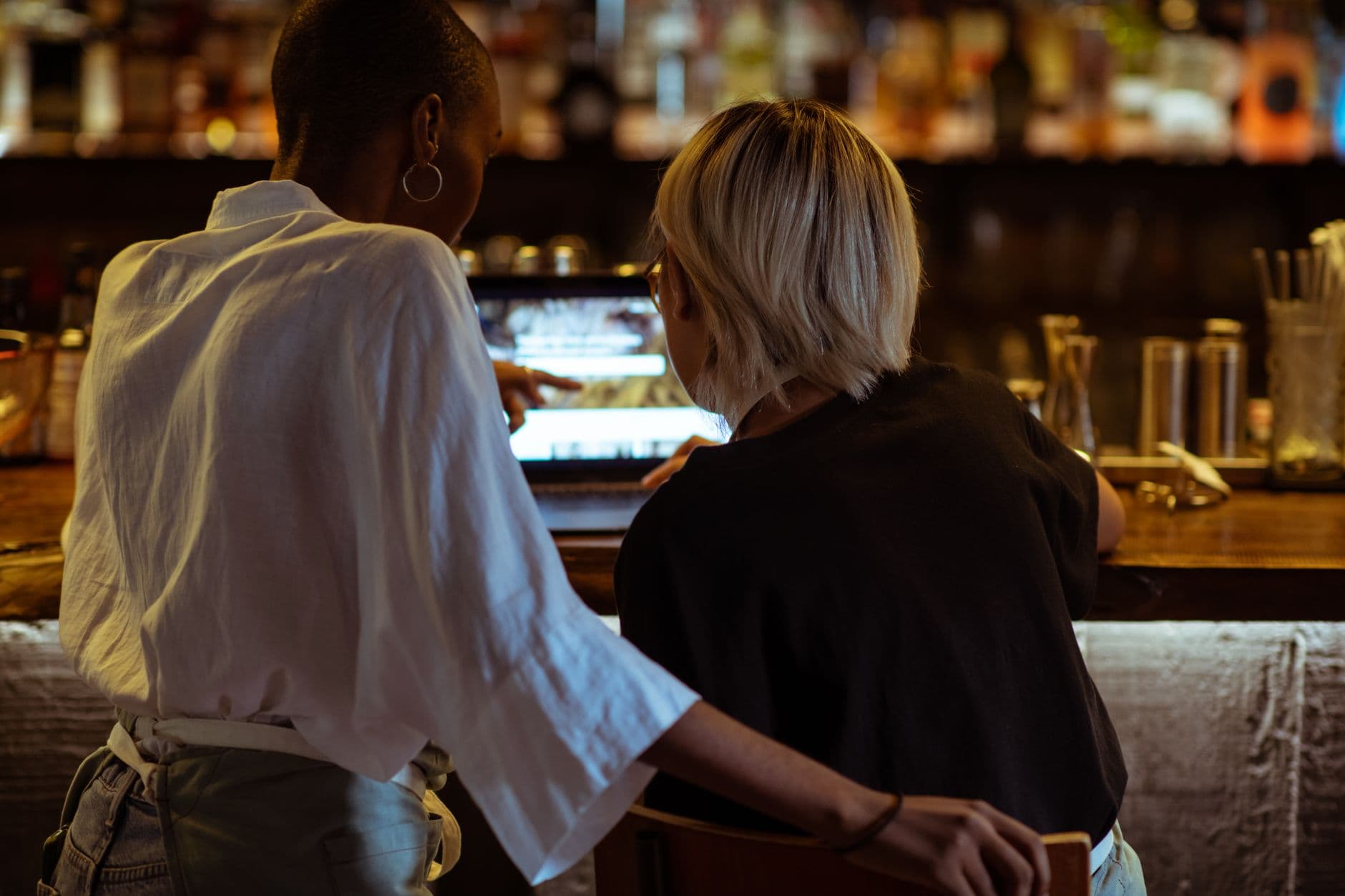 MEI e nota avulsa: quando usar e quando evitar Back view unrecognizable diverse restaurant workers surfing modern netbook while sitting ar bar counter in cozy restaurant