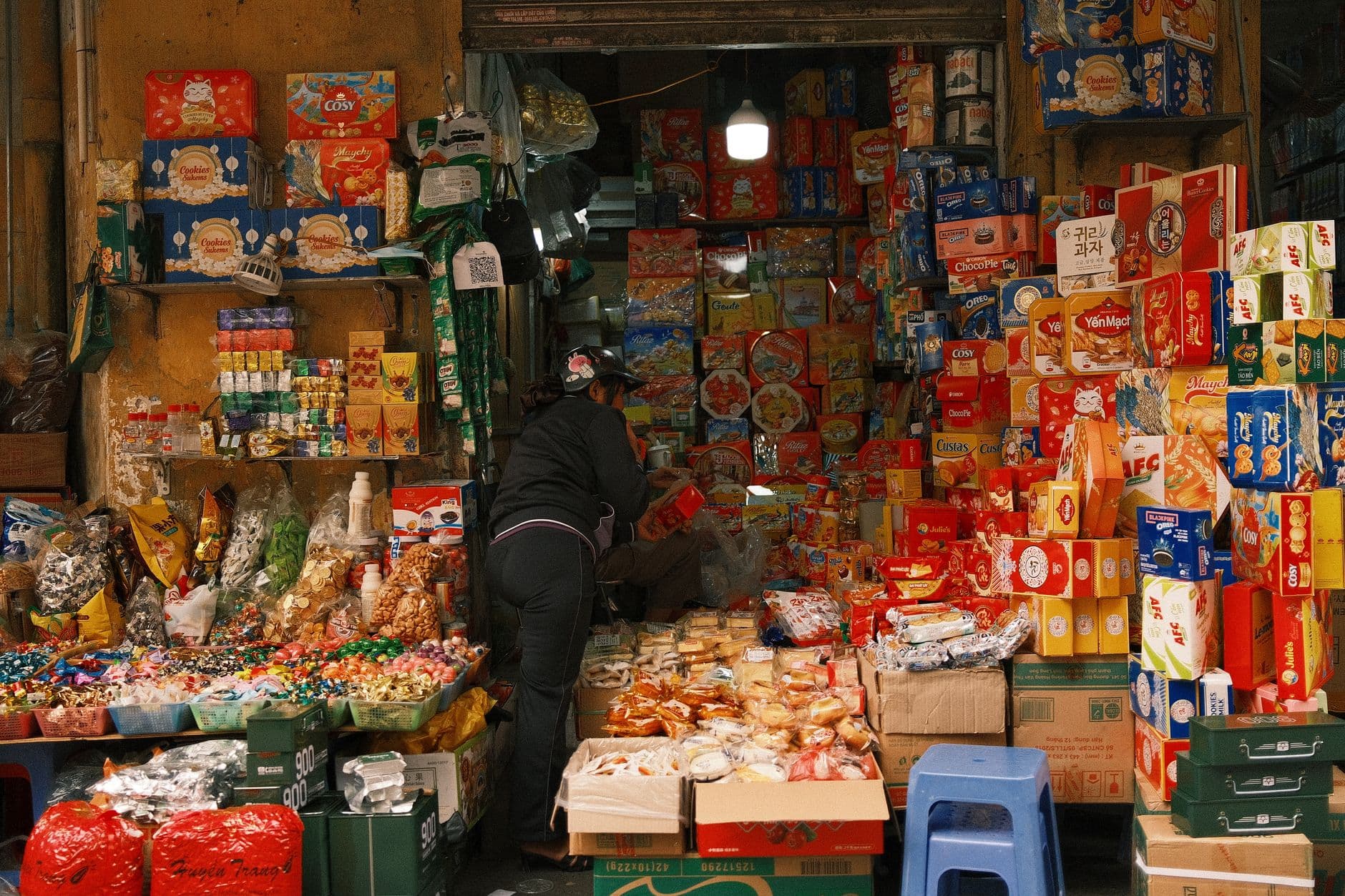 MEI que vende produto: qual nota emitir e onde A vibrant snack shop with diverse packaged snacks and candies in a bustling market.