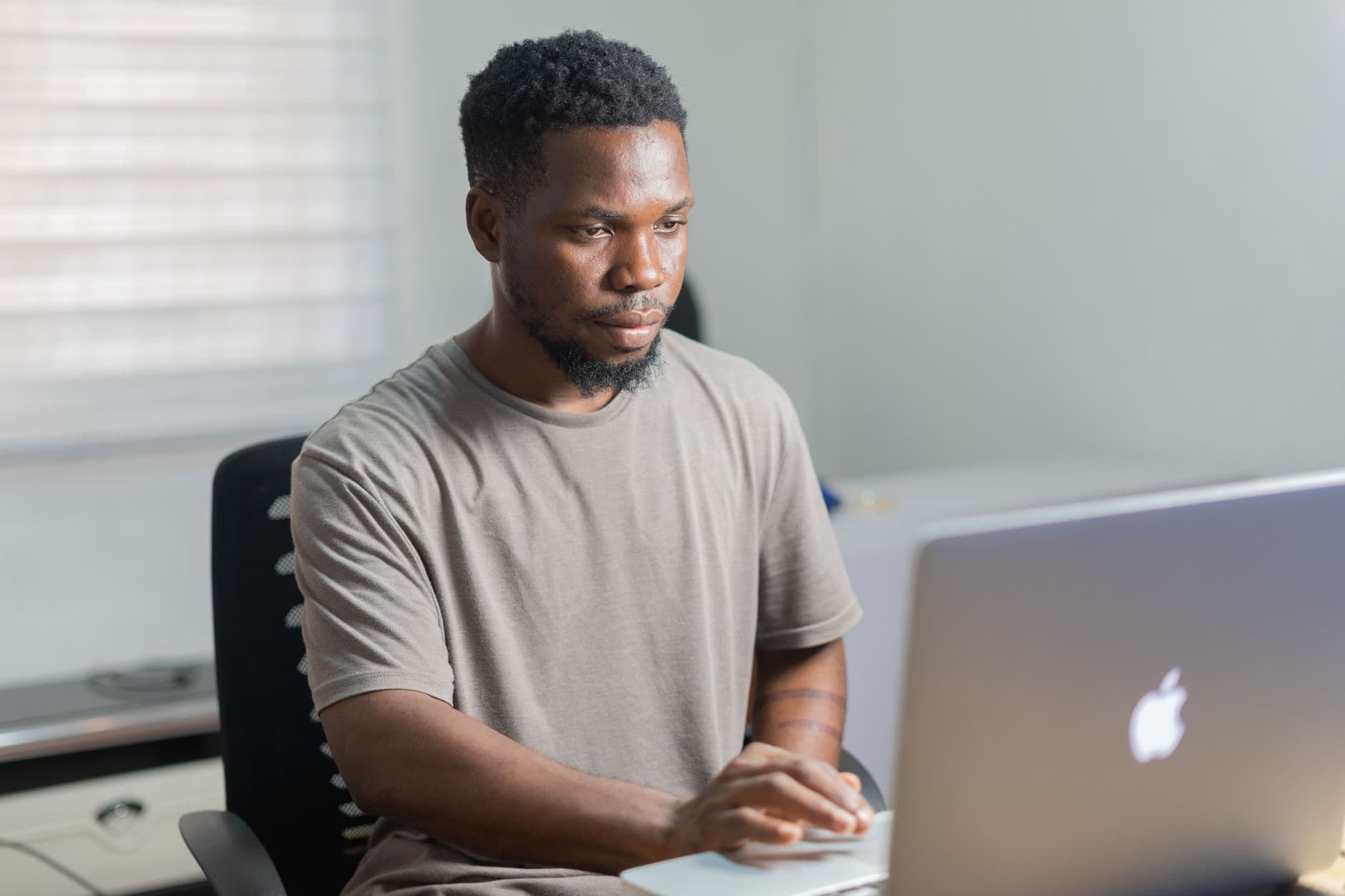 MEI precisa emitir nota para pessoa física? African American man working remotely on a laptop in a well-lit indoor setting.