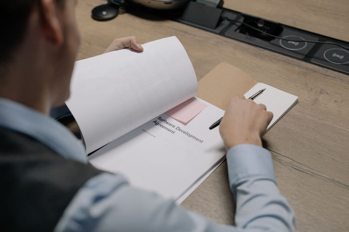 Pessoa empreendedora revisando contrato e documentos de prestação de serviço para cliente estrangeiro.