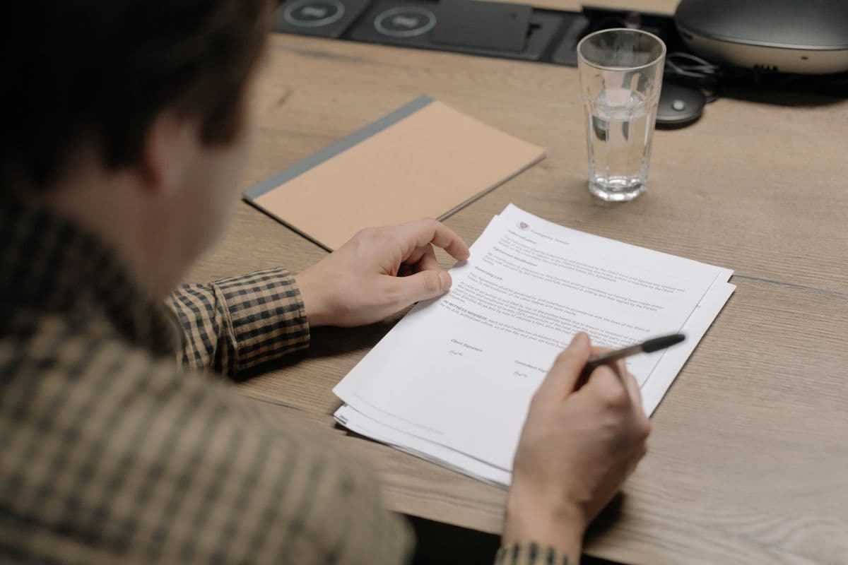 Profissional autônomo analisando contrato e documentos em uma mesa de trabalho