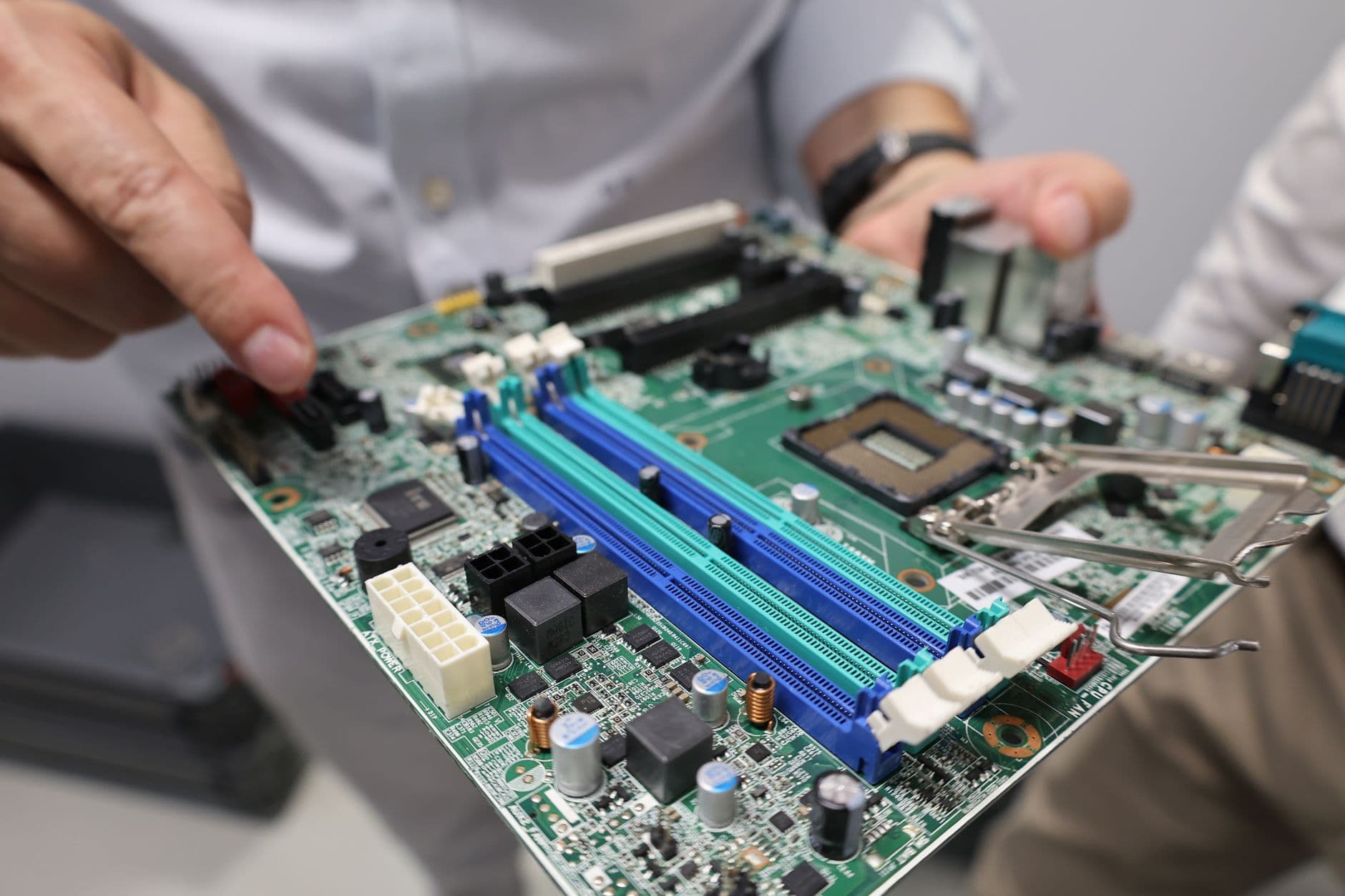 Não consigo acessar o portal da NFS-e: o que verificar Close-up of a technician handling a computer motherboard, emphasizing technology and electronics.