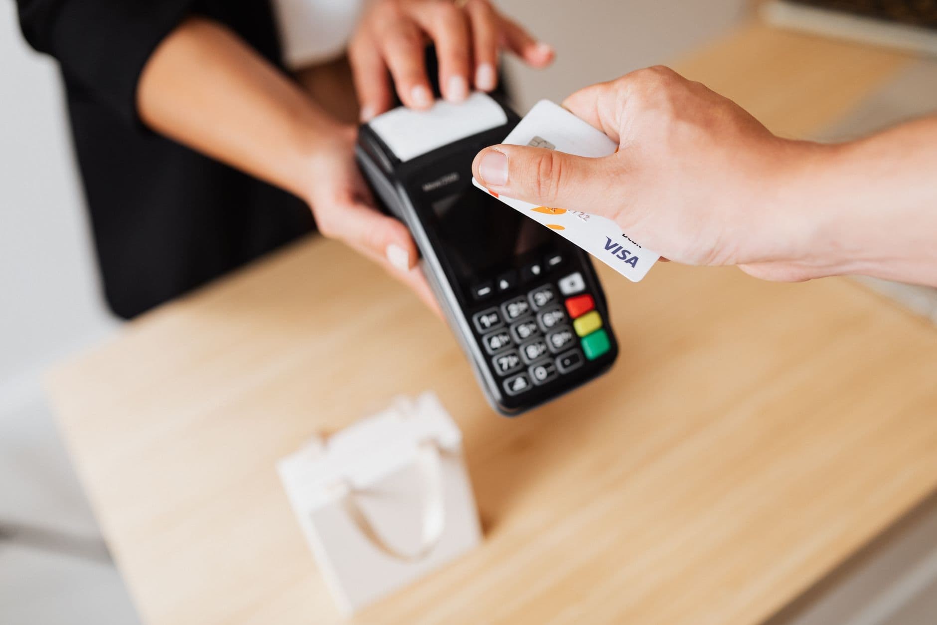 Atendente de loja digitando dados de compra no caixa do estabelecimento