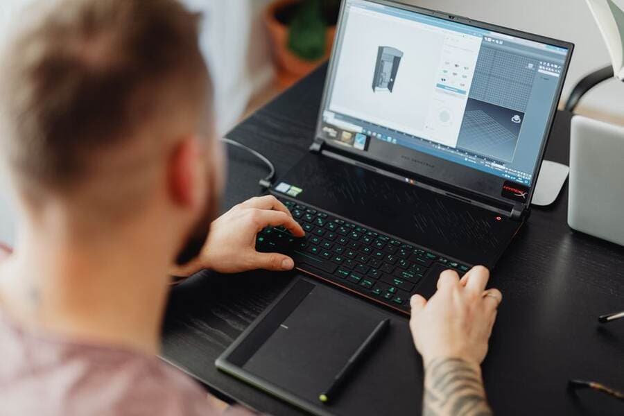 Profissional trabalhando em um modelo 3D no notebook Profissional trabalhando em um modelo 3D no notebook