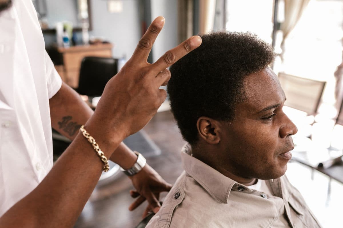 Barbeiro organizando atendimento e documentos fiscais no balcão da barbearia.