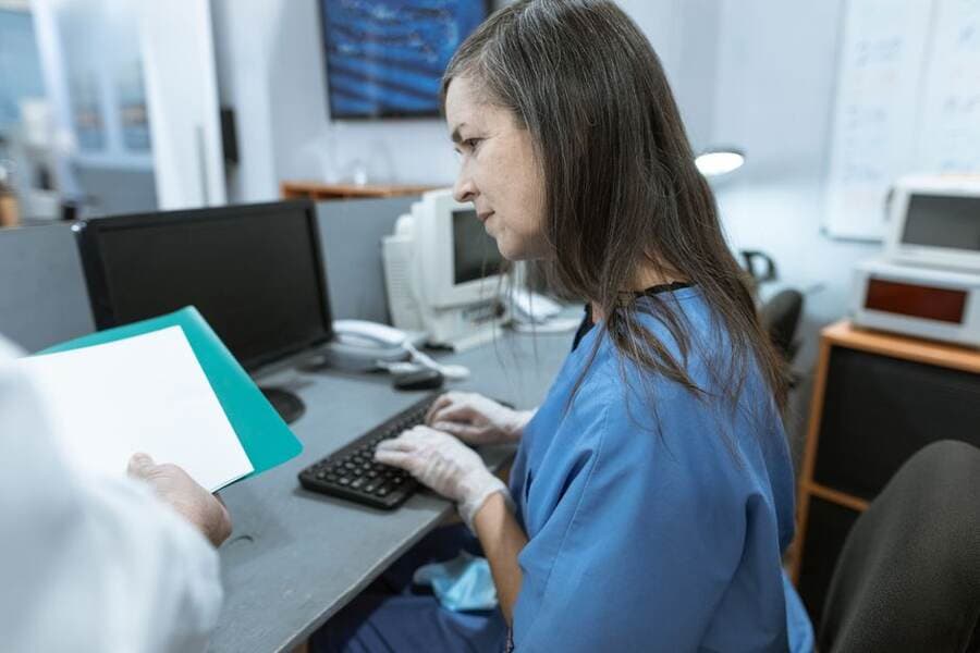 Recepção de clínica com computador e documentos Recepção de clínica com computador e documentos