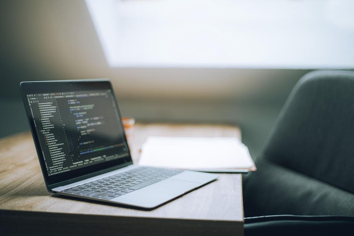 Programador escrevendo código no notebook