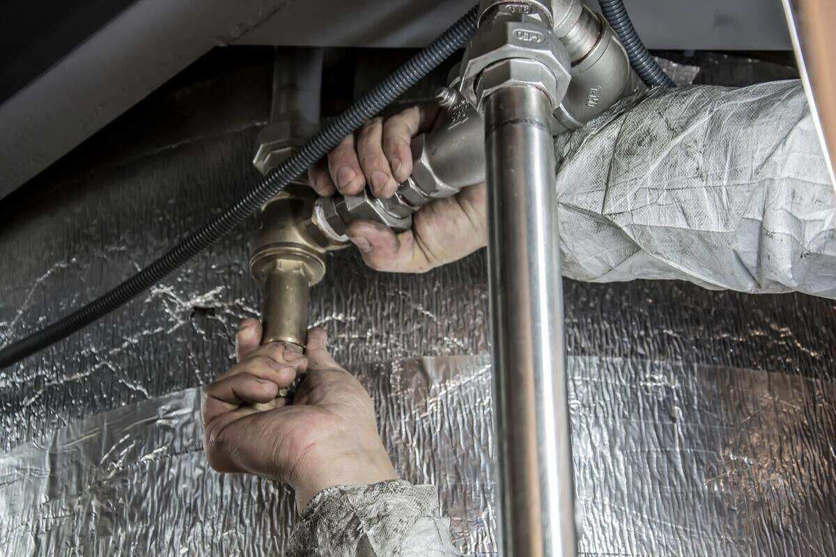 E o material usado no serviço? Mãos de encanador instalando canos de metal