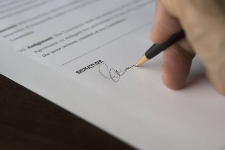 Contrato de prestação de serviço sendo assinado sobre a mesa Contrato de prestação de serviço sendo assinado sobre a mesa