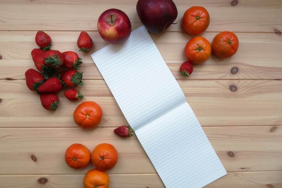Caderno de plano alimentar ao lado de frutas e vegetais Caderno de plano alimentar ao lado de frutas e vegetais