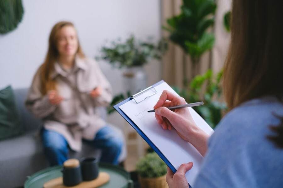 Profissional fazendo anotações durante um atendimento Profissional fazendo anotações durante um atendimento